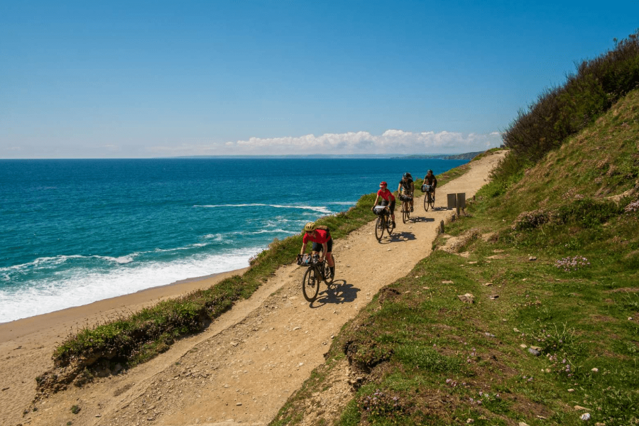Cyclists riding the West Kernow Way coastal trail in Cornwall. Photograph: Jordan Gibbons / Pannier.